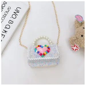 Dettaglio di borsa bimba in tweed colorato con cuore rosa e manico di perle