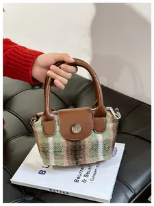 Vista dall'alto di borsa per bambini in lana a quadretti con patta in pelle marrone