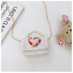 Dettaglio borsa a tracolla in tweed per bambini con pizzo, cuore rosa e perline