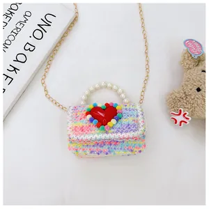 Dettaglio borsa bimbi in tweed colorato con cuore rosso e manico in perle finte