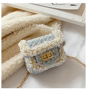 Close-up of multicolored tweed fabric texture and white pearl trim on mini crossbody bag