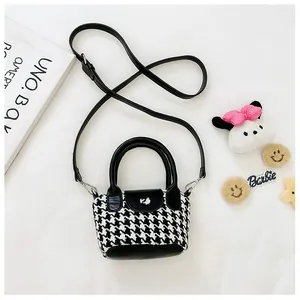 Dettaglio borsa bimba pied-de-poule con manico in pelle e fiocco di peluche rosa