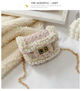 Detail of pink tweed crossbody bag with white pearls and gold metal chain strap