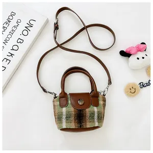Dettaglio della borsa in tweed a quadri verde e marrone con tracolla e bottone vintage