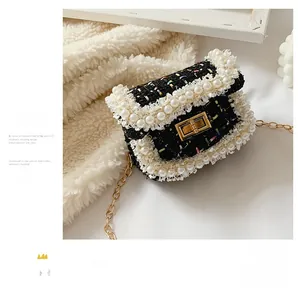 Detail of tweed kids crossbody bag with pearl trim, gold square lock, and metal chain