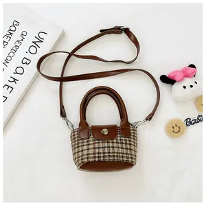 Dettaglio borsa bimbi in tweed scozzese retrò e pelle marrone con chiusura in metallo