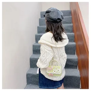 Detail view of green tweed kids crossbody bag with pearl handle and 3D flower decor