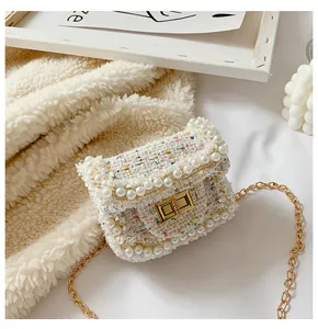 Detail of colorful tweed mini bag with pearl trim, gold twist lock and metal chain strap