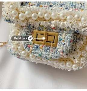 Detailed view of tweed shoulder bag with elegant pearl trim and gold hardware lock
