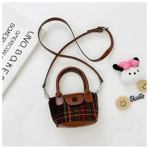 Vista dall'alto di una mini borsa vintage a quadri in tweed con manico e tracolla in pelle