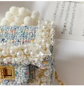 Close-up of multicolor tweed bag featuring elegant lace trim, large pearls and gold metal lock
