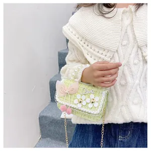 Detail of green tweed kids crossbody bag with pearl handle and 3D floral accents