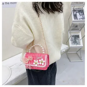 Detail of pink tweed girl's bag with pearl handle, lace trim and mesh bow accents