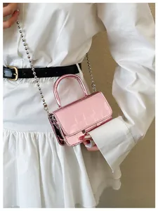 Detail of pink metallic crocodile pattern mini handbag with silver bead chain strap