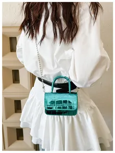 Detailed macro of metallic green crocodile pattern mini bag with silver ball chain strap