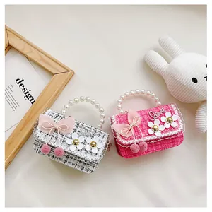 Detail of tweed children handbags with pearl handles and decorative mesh bows