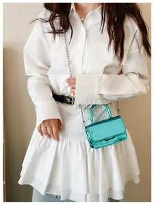 Close-up of a mini crocodile pattern handbag in metallic blue with metal bead chain