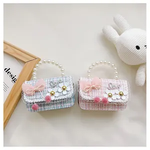 Detailed view of kids tweed plaid handbags with pearl handles and decorative bows