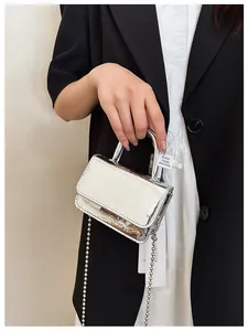 Close-up of cream faux crocodile leather handbag with silver chain and metal ball detail