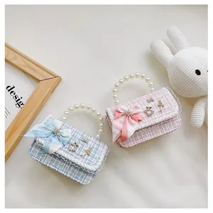 Detail of tweed mini handbags featuring pearl handles and elegant lace trim with bows