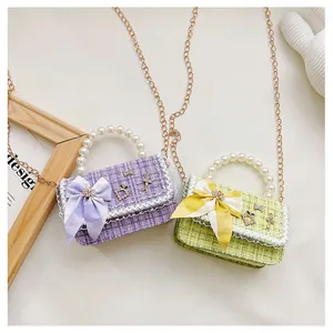 Detail of tweed kids handbags with pearl handles and decorative lace bow accents