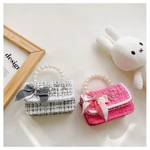 Detailed macro view of tweed children handbags with pearl handles and bow tie decorations