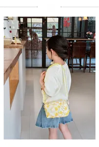 Detail of floral crossbody bag worn by a young girl, featuring 3D yellow lace flowers