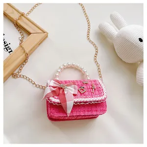 Detail of pink tweed children purse with pearl handle and bow decoration for girls