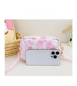 Detailed close-up of floral girls crossbody bag with pink lace strap and fabric 3D flowers
