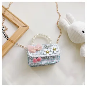 Detail of tweed kids bag with pearl handle, pink bow and Love metal charm
