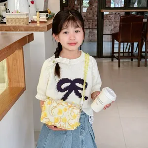 Floral crossbody bag for girls with yellow 3D flowers and lace strap worn by child