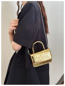 Detail of gold faux crocodile leather mini bag with decorative pearl chain strap