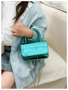 Detail of mini crocodile embossed faux leather handbag in turquoise with silver bead chain