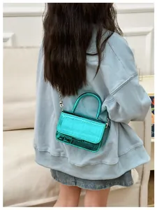 Detail view of metallic green crocodile pattern mini crossbody bag with silver chain strap