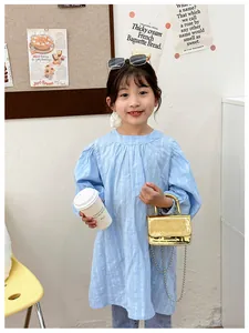 Close-up of baby blue puffed sleeve dress paired with gold crocodile pattern mini bag