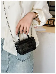 Close-up of black crocodile pattern PU leather mini handbag with silver bead chain strap