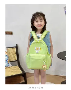 Detail of light green nylon kids backpack with fashion label and cute toast plush toy