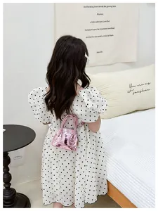 Détail d'un enfant portant un mini sac à dos rose métallique avec logo KAYIHAI au dos