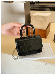 Detail of a mini black faux crocodile leather handbag with silver ball chain strap