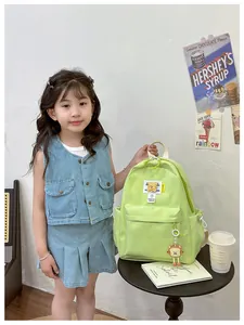 Detail of green kids backpack with Fashion Friends label and cartoon toast pendant