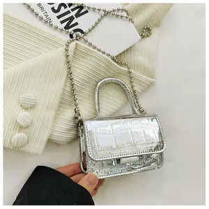 Detail of a silver mini handbag featuring crocodile pattern and beaded chain strap