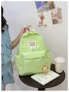 Detail of mint green nylon kids backpack with cartoon charms and fashion trend embroidery