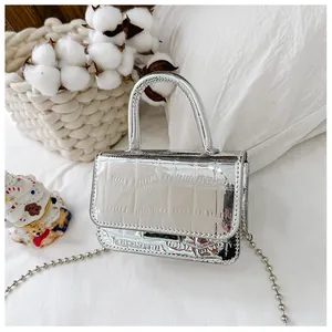 Detailed macro of silver faux leather mini bag with crocodile texture and chain