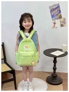 Detail of green nylon kids backpack with cartoon patches and toast pendant in cozy room