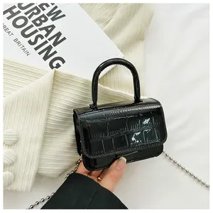 Close-up of black crocodile embossed PU leather mini bag with silver bead chain strap