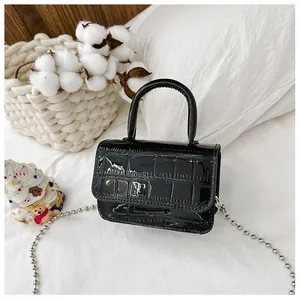 Detail of glossy black crocodile embossed mini bag with silver bead chain strap