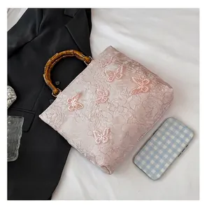 Detailed shot of pink jacquard tote bag featuring bamboo handle and 3D lace butterflies