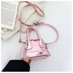 Détails d'un mini sac rose miroir avec coutures matelassées et pieds en métal