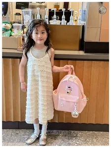 Close-up of pink children's nylon backpack featuring stitching details and cute cloud charm