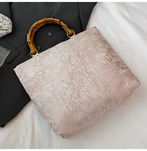 Detailaufnahme von rosa Jacquard-Stoff und dunklem natürlichem Bambusgriff